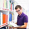 Handsome college student in library (shallow DOF; color toned image)