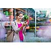 Young woman buying flowers at a garden center (color toned image; shallow DOF)