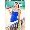 Portrait of a pretty young tennis player on the court