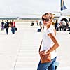 Departure - young woman at an airport about to board an aircraft on a sunny summer day