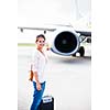 Just arrived: young woman at an airport having just left the aircraft