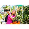 Young woman buying flowers at a garden center