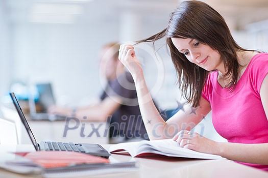 in the library - pretty female student with laptop and books working in a high school library (color toned image) in the library - pretty female student with laptop and books working in a high school library (color toned image)