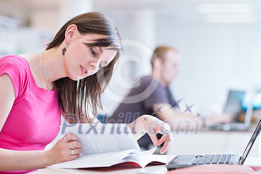 in the library - pretty female student with laptop and books working in a high school library (color toned image) in the library - pretty female student with laptop and books working in a high school library (color toned image)