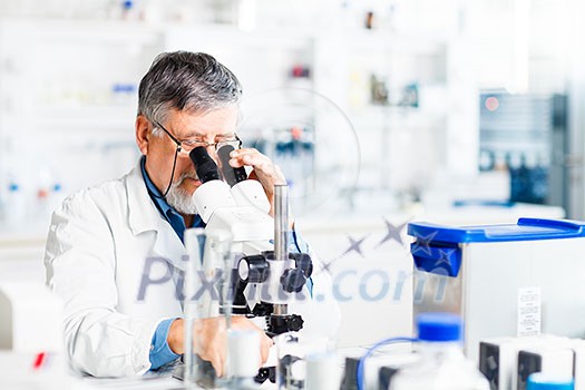 senior male researcher carrying out scientific research in a lab using a microscope (shallow DOF; color toned image) senior male researcher carrying out scientific research in a lab using a microscope (shallow DOF; color toned image)