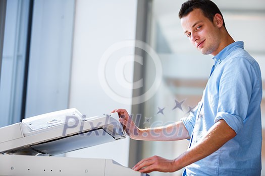 Handsome young man using a copy machine (shallow DOF; color toned image) Handsome young man using a copy machine (shallow DOF; color toned image)