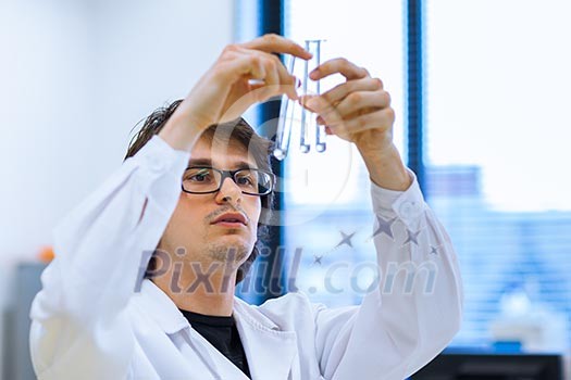Young male researcher carrying out scientific research in a lab (shallow DOF; color toned image) Young male researcher carrying out scientific research in a lab (shallow DOF; color toned image)