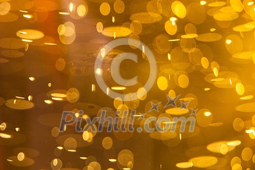 Golden macro background: gas bubbles in beer at shallow DOF against sunlight Golden macro background: gas bubbles in beer at shallow DOF against sunlight