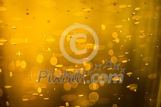 Golden macro background: gas bubbles in beer at shallow DOF against sunlight Golden macro background: gas bubbles in beer at shallow DOF against sunlight