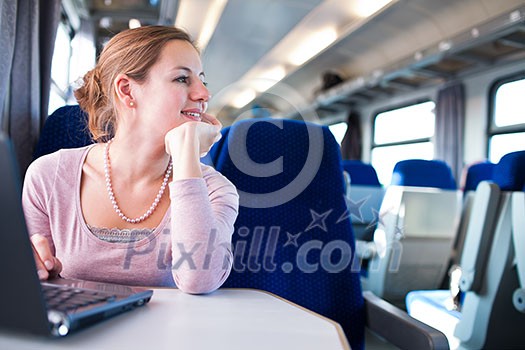 Young woman using her laptop computer while on the train (shallow DOF; color toned image) Young woman using her laptop computer while on the train (shallow DOF; color toned image)