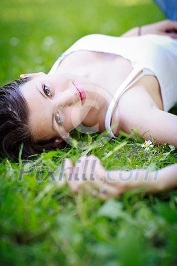 Close-up portrait of an attractive young woman outdoors, lying in the grass, relaxing Close-up portrait of an attractive young woman outdoors, lying in the grass, relaxing