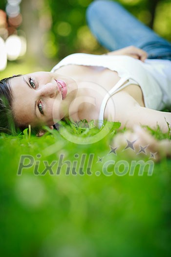 Close-up portrait of an attractive young woman outdoors, lying in the grass, relaxing Close-up portrait of an attractive young woman outdoors, lying in the grass, relaxing