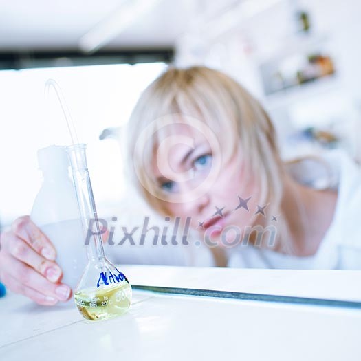 Closeup of a female researcher/chemistry student carrying out experiments in a lab (color toned image) Closeup of a female researcher/chemistry student carrying out experiments in a lab (color toned image)