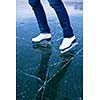 Young woman ice skating outdoors on a pond on a freezing winter day - detail of the legs