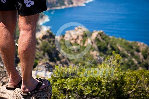 Traveler standing on a cliff (Porto region, Corsica, France) Traveler standing on a cliff (Porto region, Corsica, France)