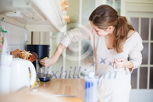 Young woman doing housework, cleaning the kitchen Young woman doing housework, cleaning the kitchen