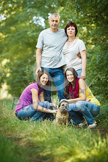 Family portrait - Family of four with a cute dog outdoors Family portrait - Family of four with a cute dog outdoors