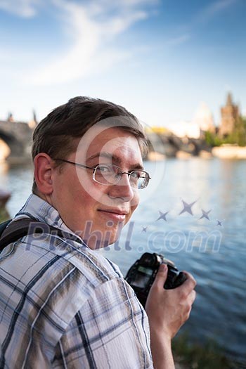Young tourist taking pictures near the Charles Bridge in Prague, Czech Republic Young tourist taking pictures near the Charles Bridge in Prague, Czech Republic