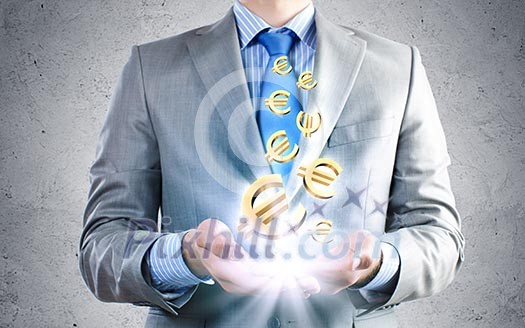 Close up of businessman holding euro symbols in palms Close up of businessman holding euro symbols in palms
