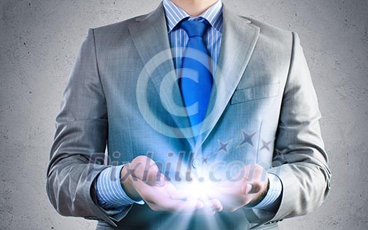 Close up of businessman holding ray of light in palms Close up of businessman holding ray of light in palms