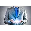 Close up of businessman holding ray of light in palms
