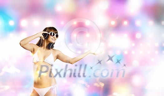 Young attractive girl in bikini wearing headphones touching media icon Young attractive girl in bikini wearing headphones touching media icon