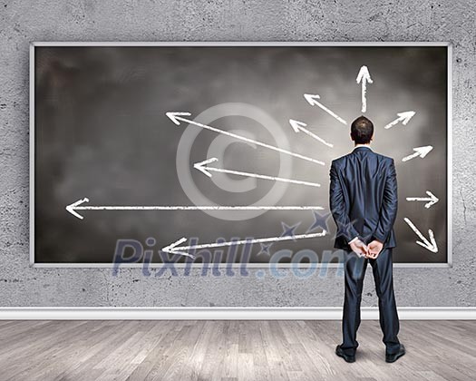 Rear view of businessman looking at chalkboard Rear view of businessman looking at chalkboard