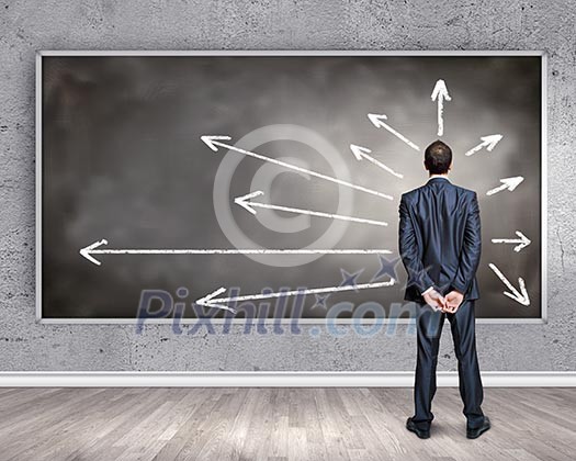 Rear view of businessman looking at chalkboard