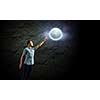 Young man and moon planet against dark background