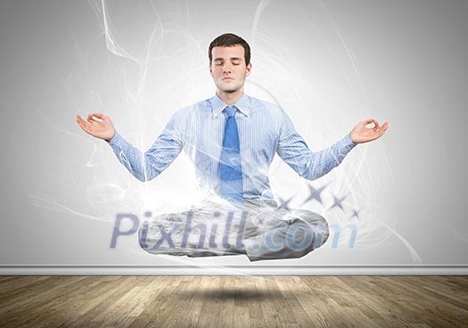 Young businessman sitting in lotus pose and meditating Young businessman sitting in lotus pose and meditating