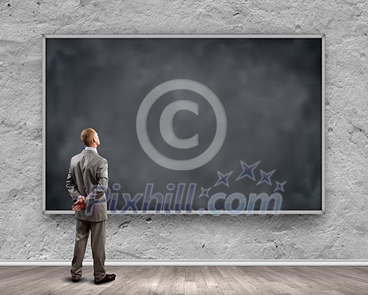 Rear view of businessman looking at chalkboard Rear view of businessman looking at chalkboard