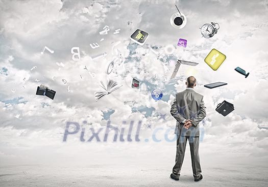 Back view of confident businessman looking at city with items flying in air Back view of confident businessman looking at city with items flying in air