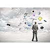 Back view of confident businessman looking at city with items flying in air
