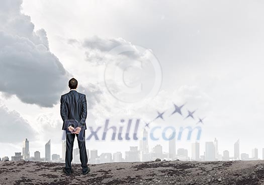 Back view of confident businessman looking at city Back view of confident businessman looking at city