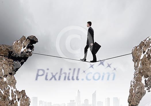 Conceptual image of businessman walking on rope above gap Conceptual image of businessman walking on rope above gap