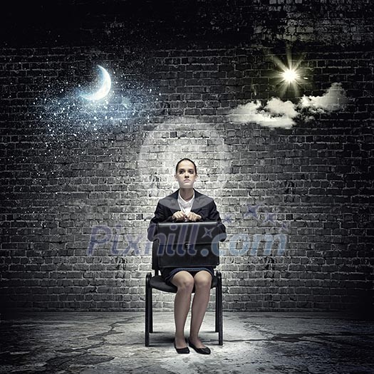 Young upset businesswoman with suitcase sitting on chair Young upset businesswoman with suitcase sitting on chair