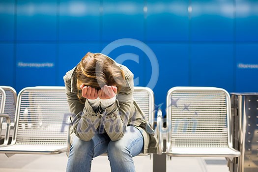 Sad and alone in a big city - Depressed young woman sitting in a metro station, feeling sorrow, regret Sad and alone in a big city - Depressed young woman sitting in a metro station, feeling sorrow, regret