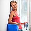 Pretty, young woman doing house work - washing windows