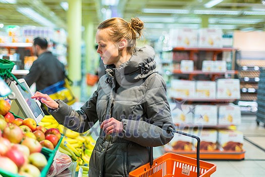Beautiful, young woman shopping for fruits and vegetables in produce department of a grocery store/supermarket (shallow DOF; color toned image) Beautiful, young woman shopping for fruits and vegetables in produce department of a grocery store/supermarket (shallow DOF; color toned image)