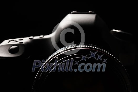 Professional modern DSLR camera low key image - Modern DSLR camera with a very wide aperture lens on Professional modern DSLR camera low key image - Modern DSLR camera with a very wide aperture lens on