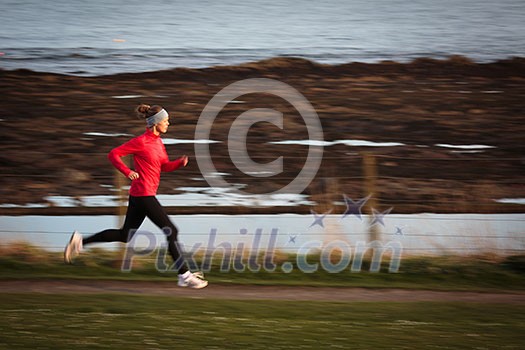 Young woman on her evening jog along the seacoast Young woman on her evening jog along the seacoast