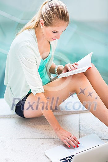 On campus - pretty, female student with books and laptop working while on a college/university campus (color toned image, shallow DOF) On campus - pretty, female student with books and laptop working while on a college/university campus (color toned image, shallow DOF)