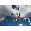 Basketball hoop against  lovely blue summer sky with some fluffy white clouds