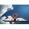 Basketball hoop against  lovely blue summer sky with some fluffy white clouds