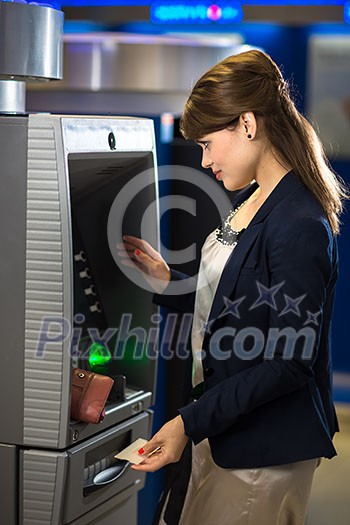 Pretty, young woman withdrawing money from her credit card in at an ATM (shallow DOF; color toned image) Pretty, young woman withdrawing money from her credit card in at an ATM (shallow DOF; color toned image)