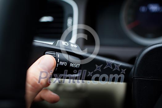 Modern car interior - driver pressing a button, using the car computer Modern car interior - driver pressing a button, using the car computer