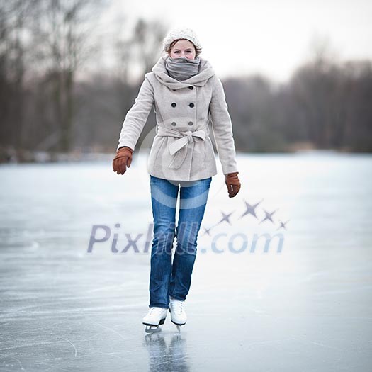 Young woman ice skating outdoors on a pond on a freezing winter day Young woman ice skating outdoors on a pond on a freezing winter day