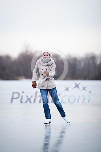 Young woman ice skating outdoors on a pond on a freezing winter day Young woman ice skating outdoors on a pond on a freezing winter day