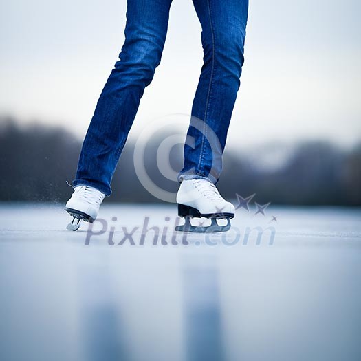 Young woman ice skating outdoors on a pond on a freezing winter day Young woman ice skating outdoors on a pond on a freezing winter day