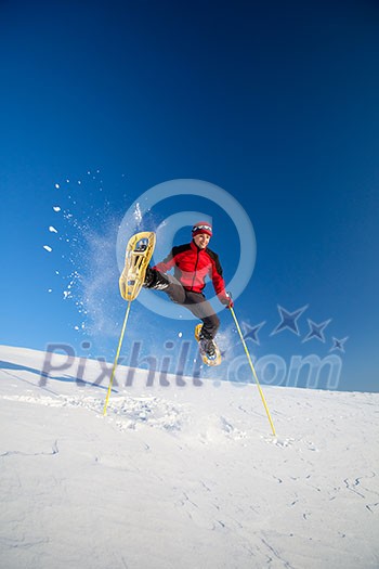 Young man showshoeing outdoors on a lovely snowy winter day (motion blurred image) Young man showshoeing outdoors on a lovely snowy winter day (motion blurred image)